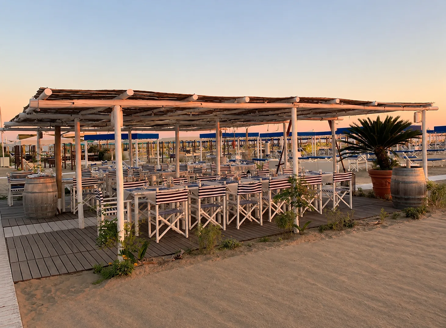 Tavoli apparecchiati al tramonto sotto la pergola del Bagno Carla, Forte dei Marmi