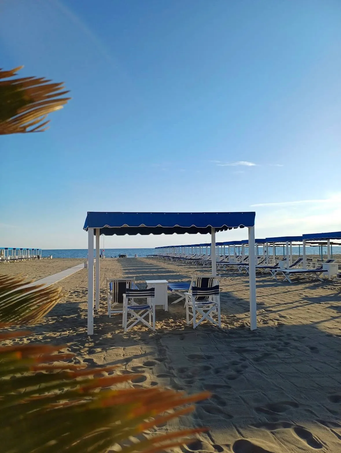 Gazebo blu sulla spiaggia del Bagno Carla nella luce dorata, Vittoria Apuana