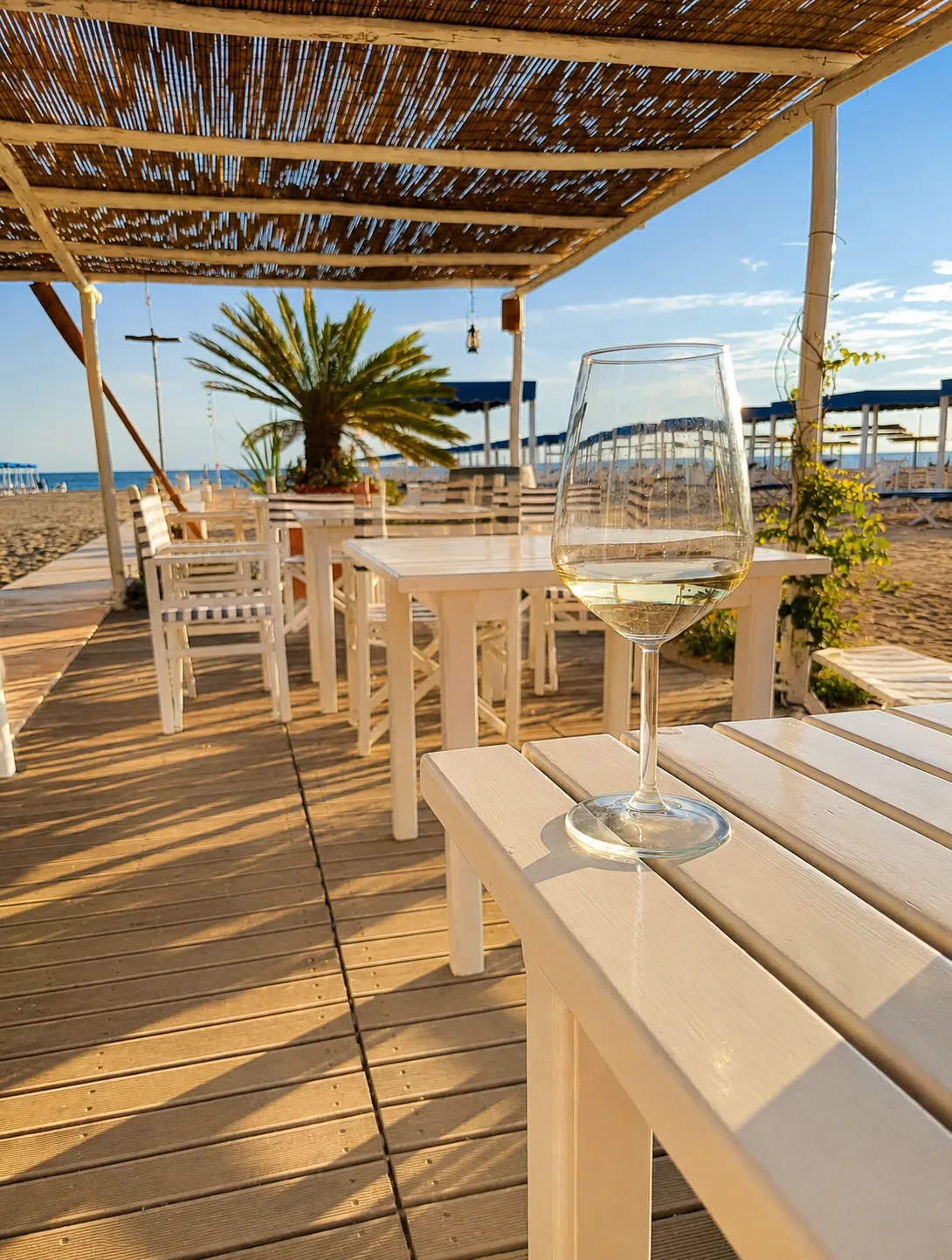 Tavoli e sedie sotto la pergola in canne del bar del Bagno Carla, vista mare, Forte dei Marmi